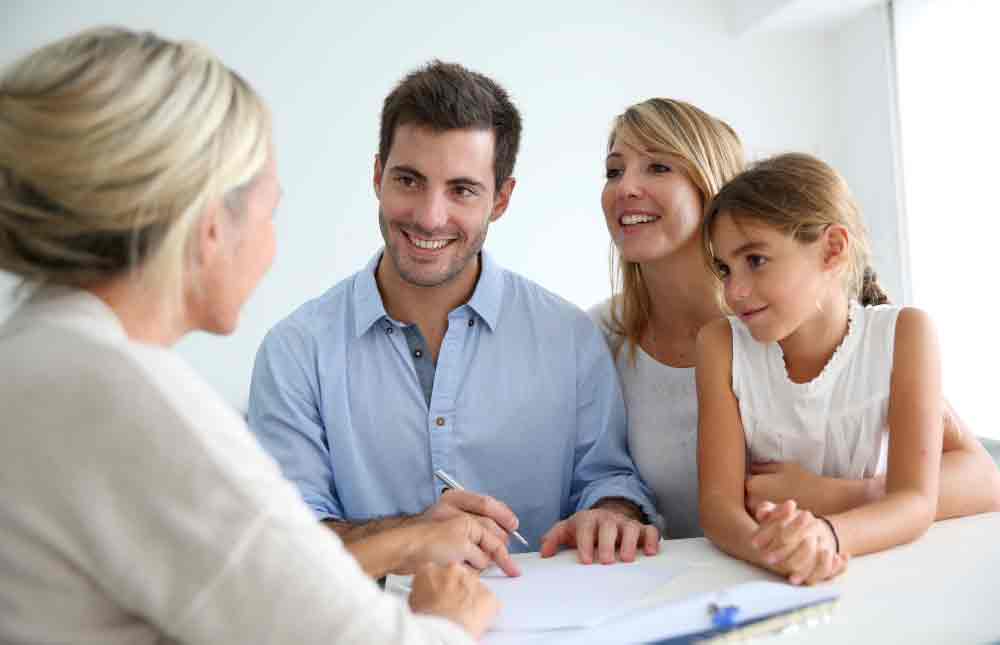 Couple signing contract with real estate agent