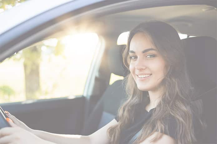 Mujer soriendo dentro del coche