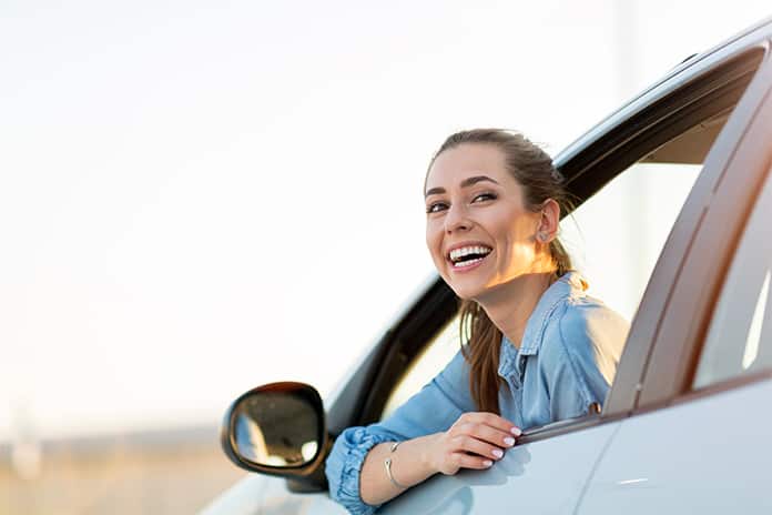Mujer soriendo dentro del coche